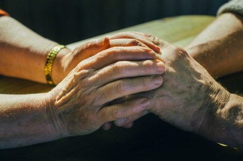 ystävät pitävät toisiaan käsistä , kädet päällekäin, toinen on vanhempi henkilö